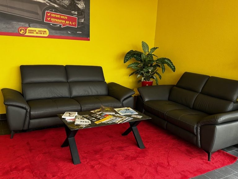 Empfangs- und Wartebereich beim Scheiben-Doktor Halle mit Sitzgruppe in den Markenfarben Rot und Gelb